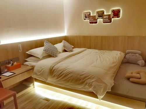 a bedroom with a large bed and a desk at Andy International Hotel Shenzhen University Nanshan Metro Station Branch in Shenzhen