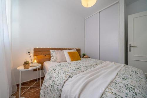 a white bedroom with a bed and a night stand at Balcones del Mar By Solymar Holiday in Torrox Costa
