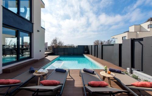 ein Außenpool mit Chaiselongue und ein Haus in der Unterkunft Ferienhaus mit Privatpool für 6 Personen ca 200 m in Poreč, Istrien Istrische Riviera in Poreč