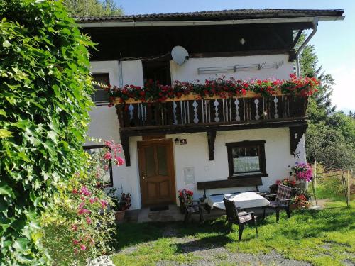 ein Haus mit einem Balkon mit Blumen darauf in der Unterkunft Ruhig am Waldrand gelegene Wohneinheit in Innsbruck