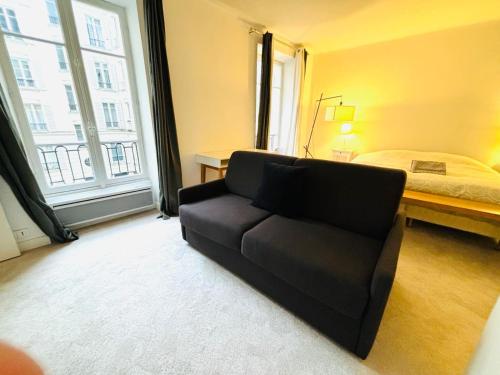 un salon avec un canapé et un lit dans l'établissement Appartement Champ de Mars Grenelle Paris, à Paris