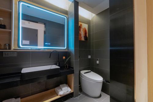 a bathroom with a toilet and a sink and a mirror at Andy International Hotel Shenzhen University Nanshan Metro Station Branch in Shenzhen