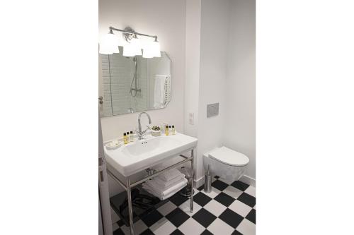 a bathroom with a sink and a mirror and a toilet at Villa Aitama in Cap-Ferret