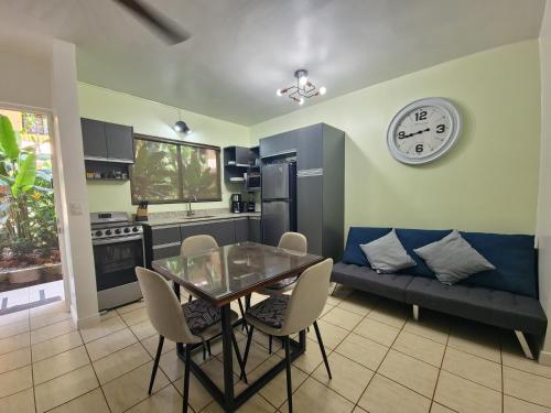 a kitchen with a dining table and a clock on the wall at A Little Bit Of Paradise Ground Floor Studio in Coco