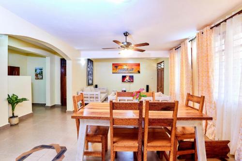 a dining room with a wooden table and chairs at Diani Beach Gold Apartments in Diani Beach