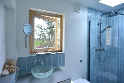 a bathroom with a glass bowl sink and a window at Fen Cottage, Walberswick in Walberswick