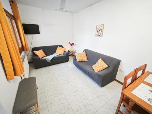 a living room with two couches and a table at El Penell Apartament Xaloc in Vilamaniscle