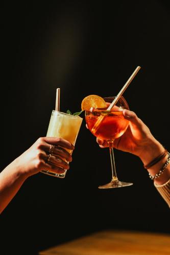two hands holding two cocktails on a table at Mercure Arras Centre Gare in Arras