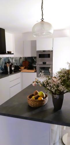 une cuisine avec une corbeille de fruits sur un comptoir dans l'établissement Gîte Saint Benoît sur Loire Val de Sully, à Saint-Benoît-sur-Loire