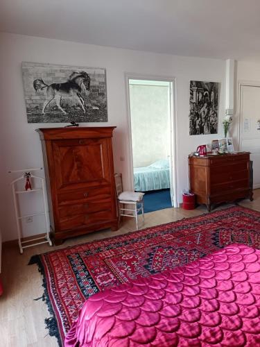 a bedroom with a large pink bed and a dresser at Lalobema in Machecoul