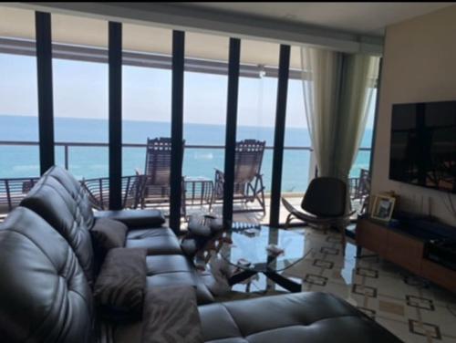 a living room with a couch and a view of the ocean at Panorama Seaview Suite Escape Front in Mae Pim