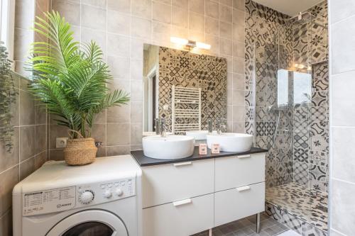 une salle de bain avec deux lavabos et une machine à laver dans l'établissement Mulhouse parking gratuit Centre, à Mulhouse