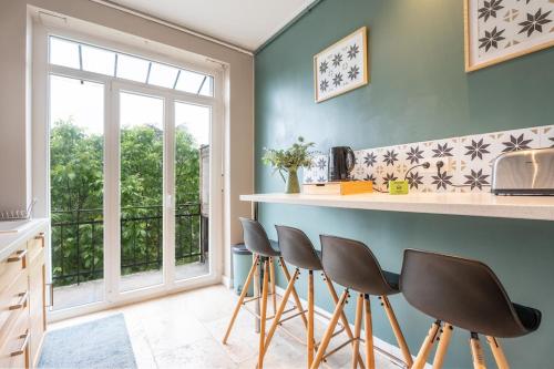 une cuisine avec un comptoir et des tabourets devant une fenêtre dans l'établissement Mulhouse parking gratuit Centre, à Mulhouse