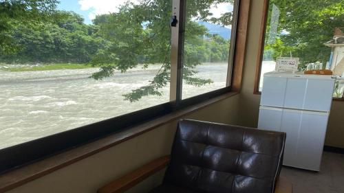 a leather chair in a room with a large window at 料理自慢の温泉宿せせらぎ荘 in Chichibu