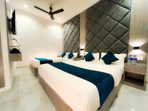 a bedroom with two beds with blue pillows at Hotel Grand Executive in Mumbai