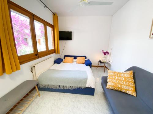 a bedroom with a bed and a couch at El Penell Apartament Xaloc in Vilamaniscle