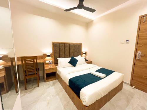 a bedroom with a bed and a desk and a chair at Hotel Grand Executive in Mumbai