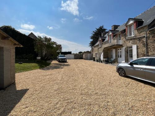 a car parked on a gravel driveway next to houses at La Maritaine in Saint-Cast-le-Guildo