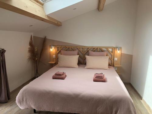 ein Schlafzimmer mit einem großen Bett mit zwei Handtüchern darauf in der Unterkunft L'Hospitalier in Saint-Antoine