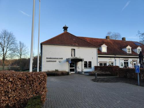 a large white building with a red roof at Tent-Ok Roggel in Roggel