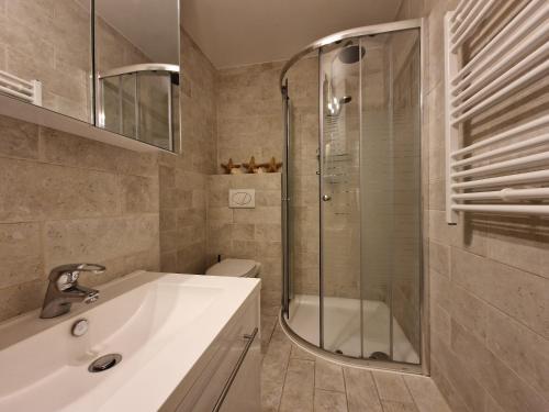 ein Badezimmer mit Dusche, Waschbecken und Toilette in der Unterkunft Premium Holidays - Studio Vriedom at the sea in Oostduinkerke