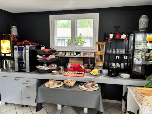 a kitchen with a table with food on it at Résidence Hôtelière La Farguaise 3min du péage in Fargues-de-Langon