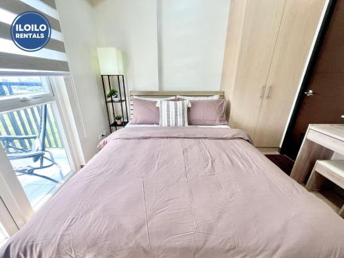 a large bed with pink sheets in a room at Room in Condo - Cozy, Modern and Homey, The Bliss Studio in Iloilo City