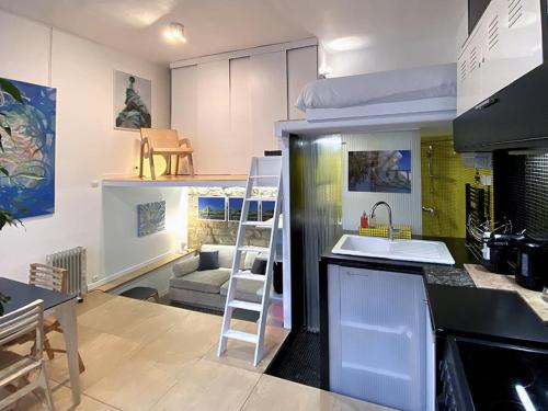 une cuisine avec des lits superposés et une cuisine avec une échelle dans l'établissement L'Atelier d'artiste, à Paris