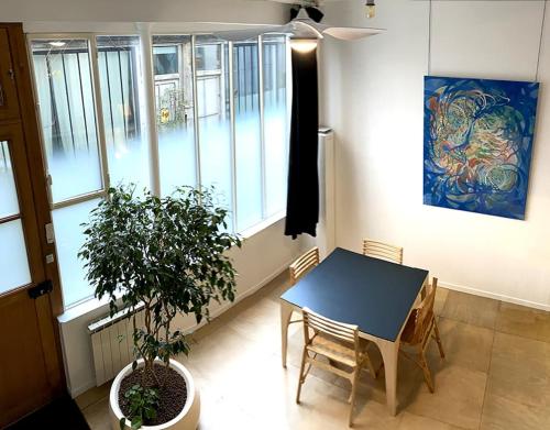 une salle à manger avec une table et une plante en pot dans l'établissement L'Atelier d'artiste, à Paris