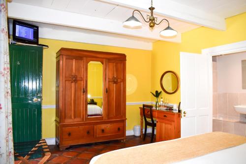 a bedroom with a bathroom with a sink and a mirror at Knorhoek Country Guesthouse in Stellenbosch