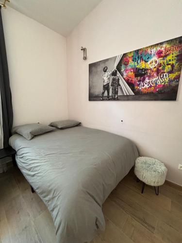 un lit dans une chambre avec un tableau sur le mur dans l'établissement Suite Lyon Coeur Monplaisir, à Lyon