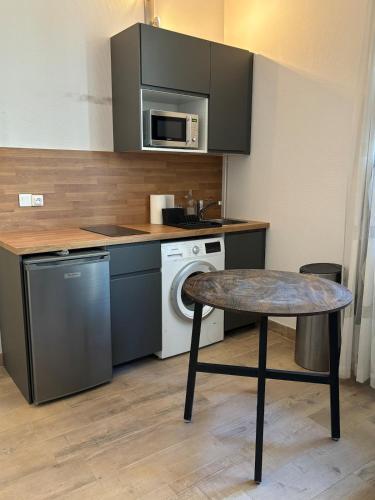 une petite cuisine avec une table et un micro-ondes dans l'établissement Suite Lyon Coeur Monplaisir, à Lyon