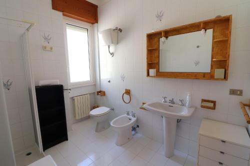 a bathroom with a sink and a toilet and a mirror at Charming Otranto Apartment Turchese Air Con Covered Parking in Otranto