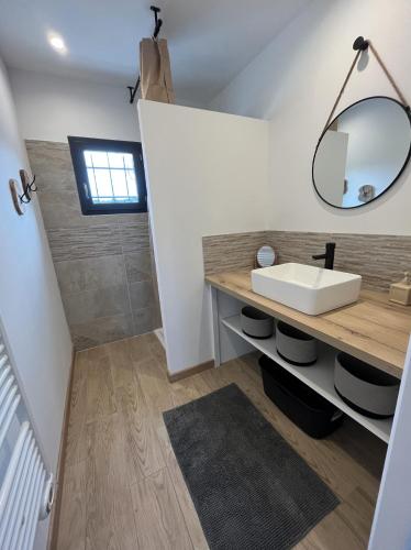 une salle de bain avec un lavabo et un miroir dans l'établissement Le Bonelli, au coeur de l'Ardèche, à Saint-Remèze