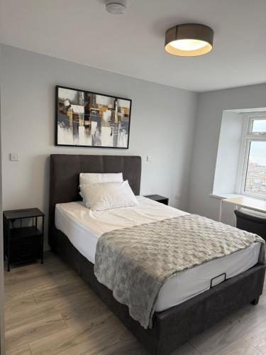 a bedroom with a large bed with white sheets at Heavenly 1 -Bedroom Retreat with Stunning sea & Garden Vistas in Swansea