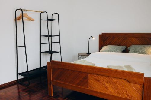 a bedroom with a bed with a wooden bed frame at Um pe na praia in Figueira da Foz