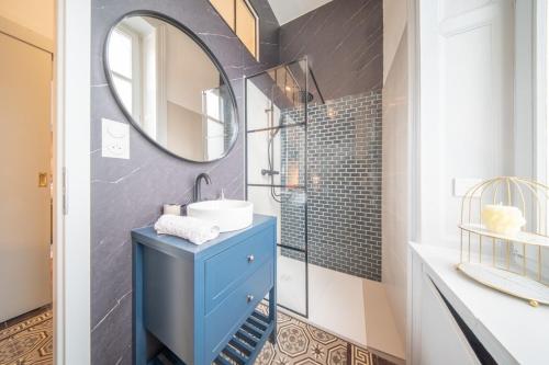 une salle de bain avec un lavabo bleu et un miroir dans l'établissement Beautiful Apartment Colmar Centre de Caractère - Private free parking included, à Colmar