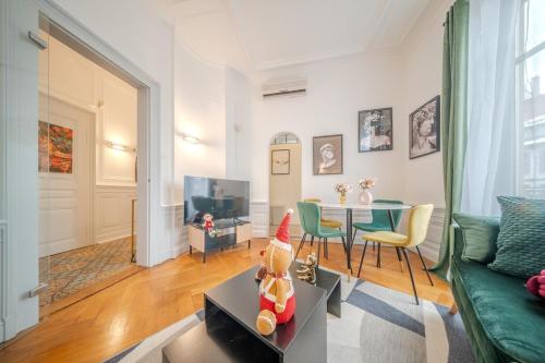 un salon avec un canapé vert et une table dans l'établissement Beautiful Apartment Colmar Centre de Caractère - Private free parking included, à Colmar