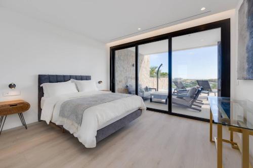 Un dormitorio con una cama y una puerta corrediza de vidrio. en Piso de lujo con piscina privada en las Colinas, en Orihuela Costa