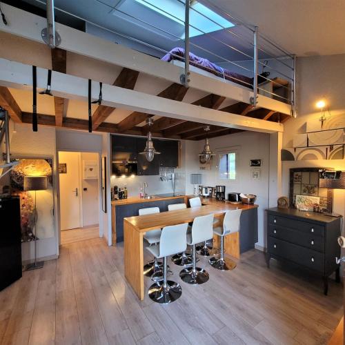 une cuisine avec une grande table en bois et des chaises blanches dans l'établissement Appartement vue montagne, à Faverges