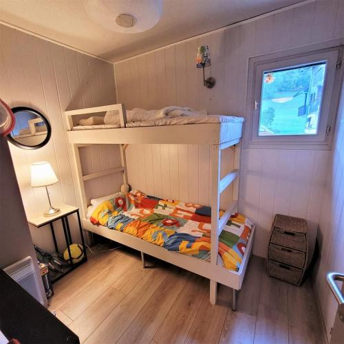 une chambre avec deux lits superposés et une fenêtre dans l'établissement Appartement vue montagne, à Faverges