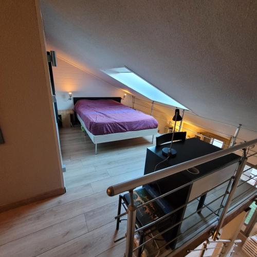 une chambre avec un lit avec une couette violette dans l'établissement Appartement vue montagne, à Faverges