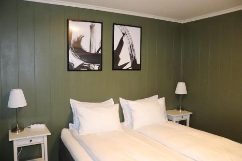 a bedroom with two beds and three pictures on the wall at Spacious 3BR Apartment - Fast Wi-Fi - Free Parking - Near Oslo Airport & City - Les Homes in Gjerdrum