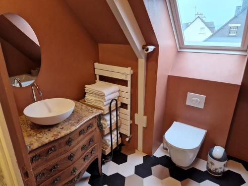 une salle de bain avec un lavabo et des toilettes et une fenêtre dans l'établissement Maison LANVALLAY, à Lanvallay