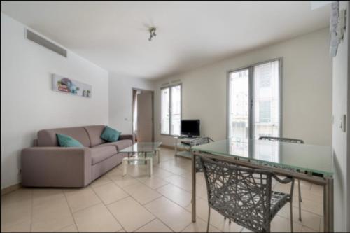 un salon avec un canapé et une table en verre dans l'établissement 39m in downtown Cannes, à Cannes