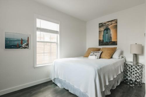 オースティンにあるNewly Renovated Downtown Gem, Spacious New Amenities Comfy King Bedのベッドと窓のある白い寝室