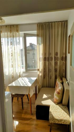 a room with a bed and a table and a window at Апартамент Калоян in Banya