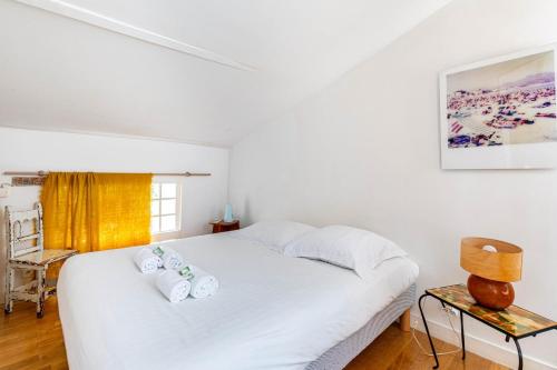 une chambre avec un lit blanc avec des serviettes dessus dans l'établissement GuestReady - Spacious retreat near Buttes-Chaumont, à Paris