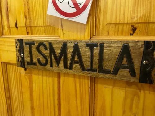 a sign on a wooden wall with a no smoking sign at The Compound in Bijilo
