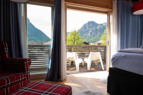 a bedroom with a bed and a large window with a view at Design Hotel ALPENLIEBE - - - - Boutique-Flair - - - - in Inzell